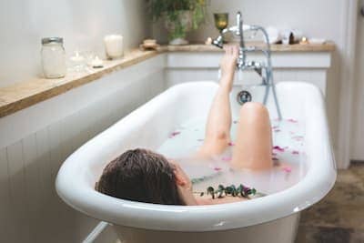 a woman indulging in a self care aromatherapy bath