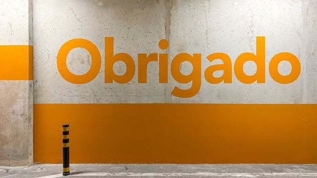 The word "Obrigado" ("thank you" in Portuguese) on a parking garage wall