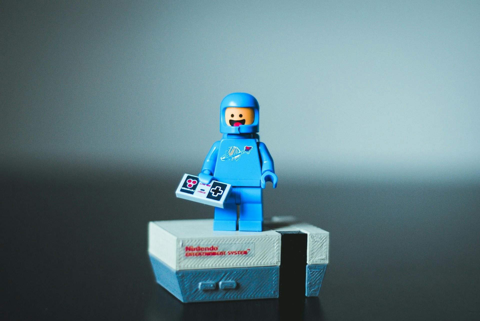 A LEGO astronaut standing on a small box giving a speech with a cheerful smile