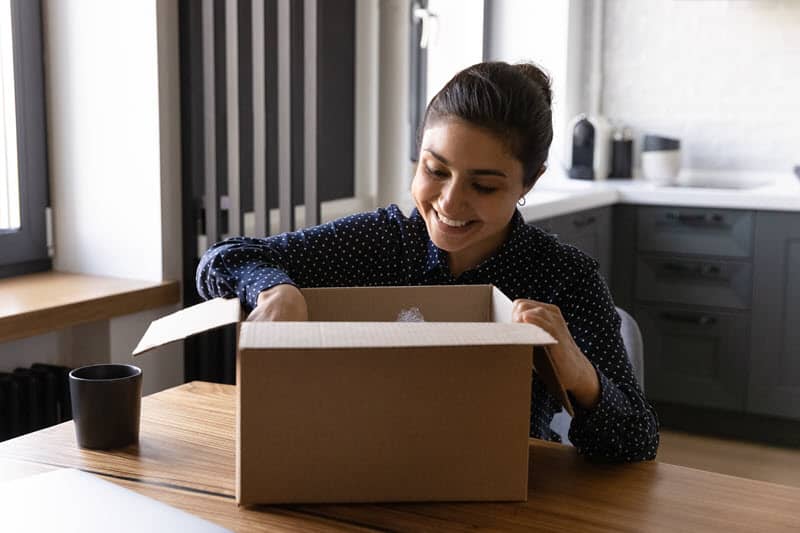 A woman unboxing a useful tool with a smile on her face