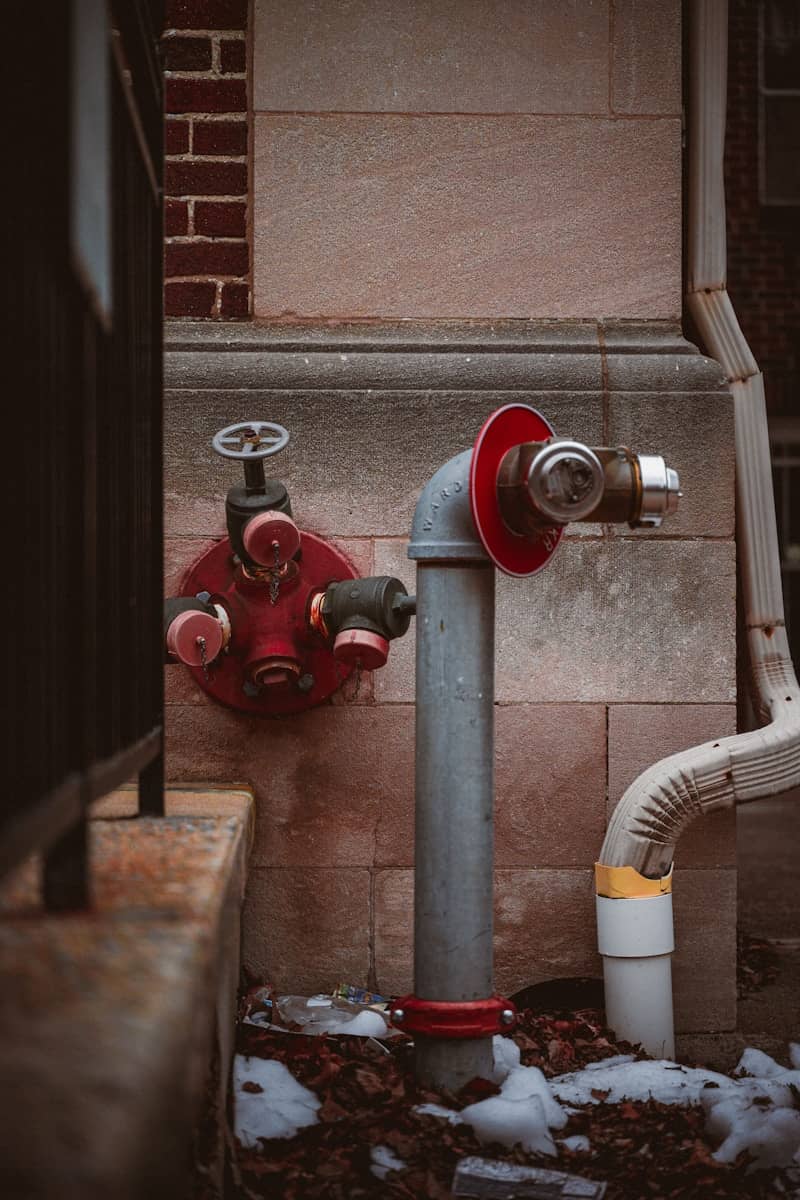 A red fire hydrant sitting next to a building