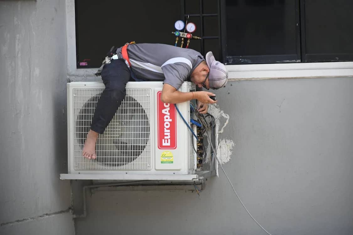 Workers are using a drill on a roof.