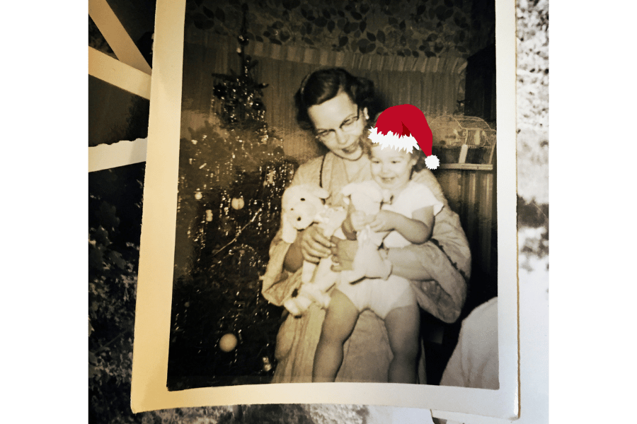 Black and white photo of woman holding child, red santa hat 