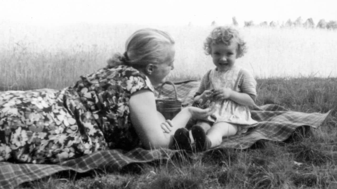 Black and white photo of mother and child on picnic blanket