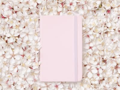 pink notebook in the midst of spring flowers