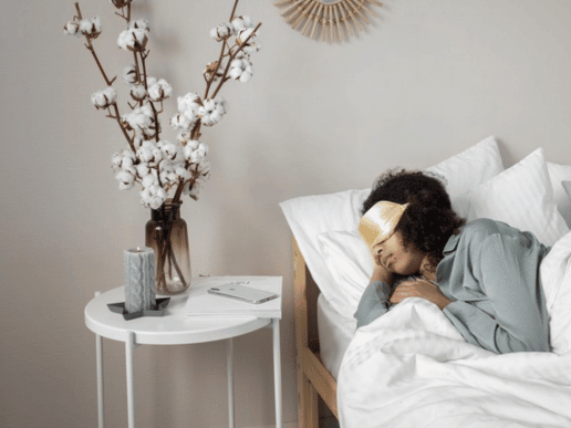 black woman sleeping with her natural hair out and a satin eye mask
