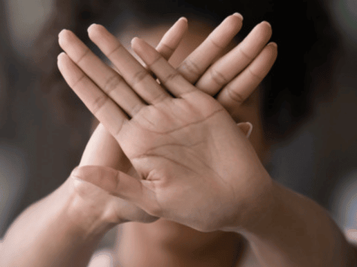 woman with her hands cross up in a hault like fashion