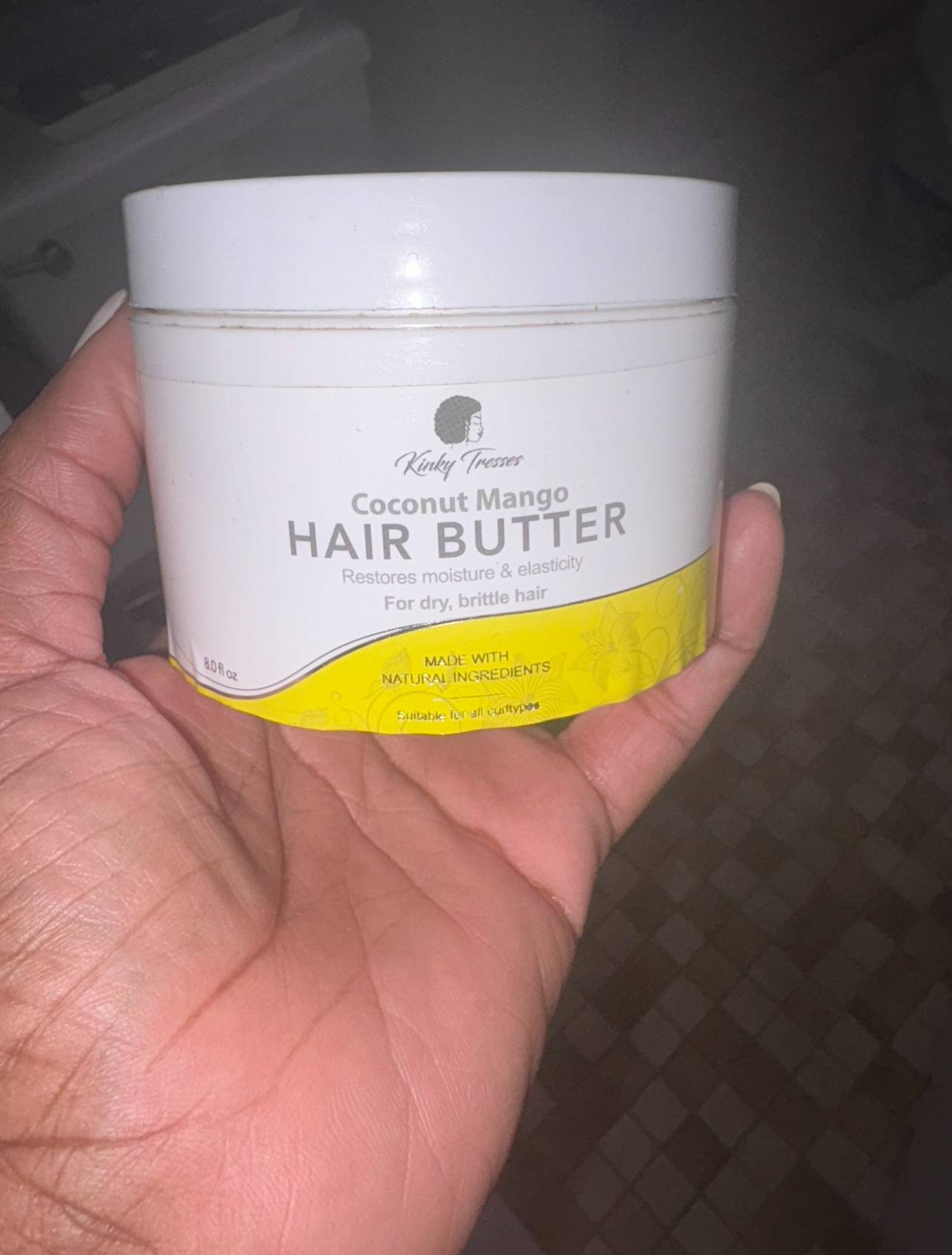 hand holding a jar of kinky tresses hair butter