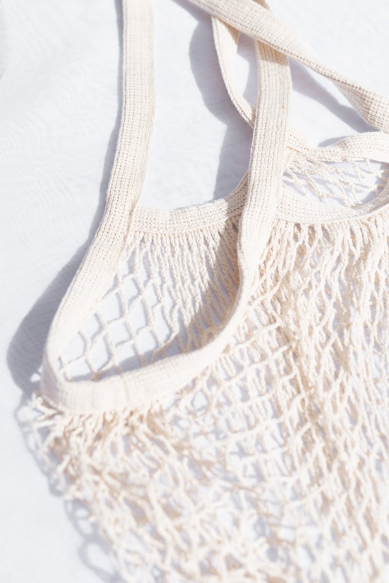 white knit bag on white textile