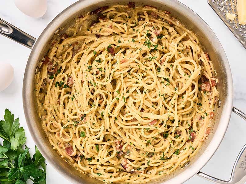 A skillet of one-pot spaghetti carbonara with eggs and Parmesan.