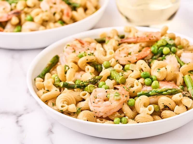 Shrimp pasta primavera, plated in pasta bowls, ready to be served.