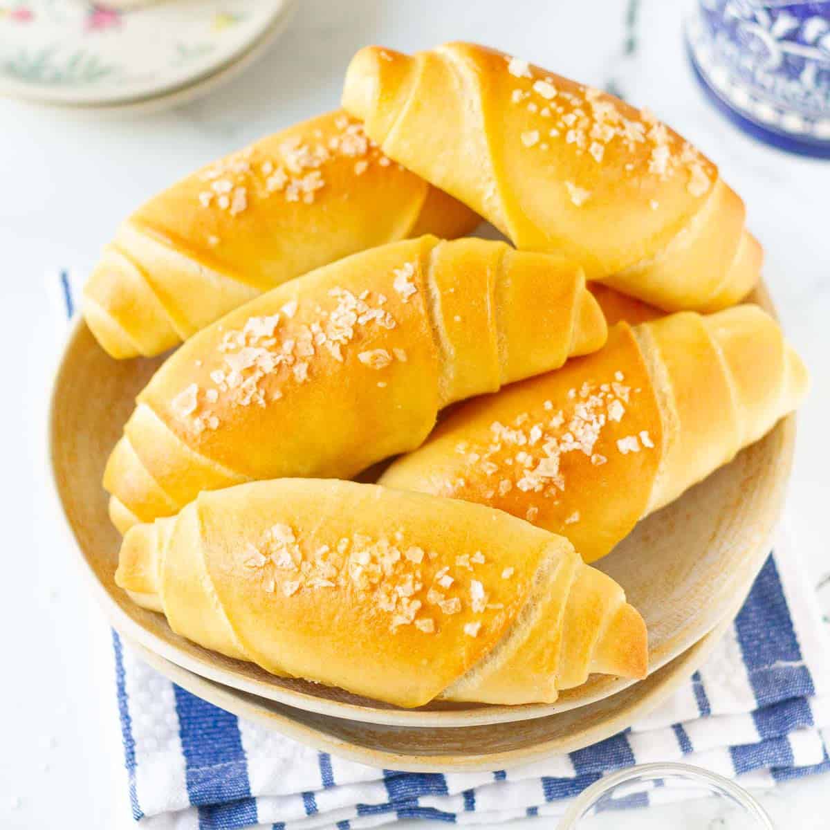 Salted butter rolls place on a ceramic bowl.