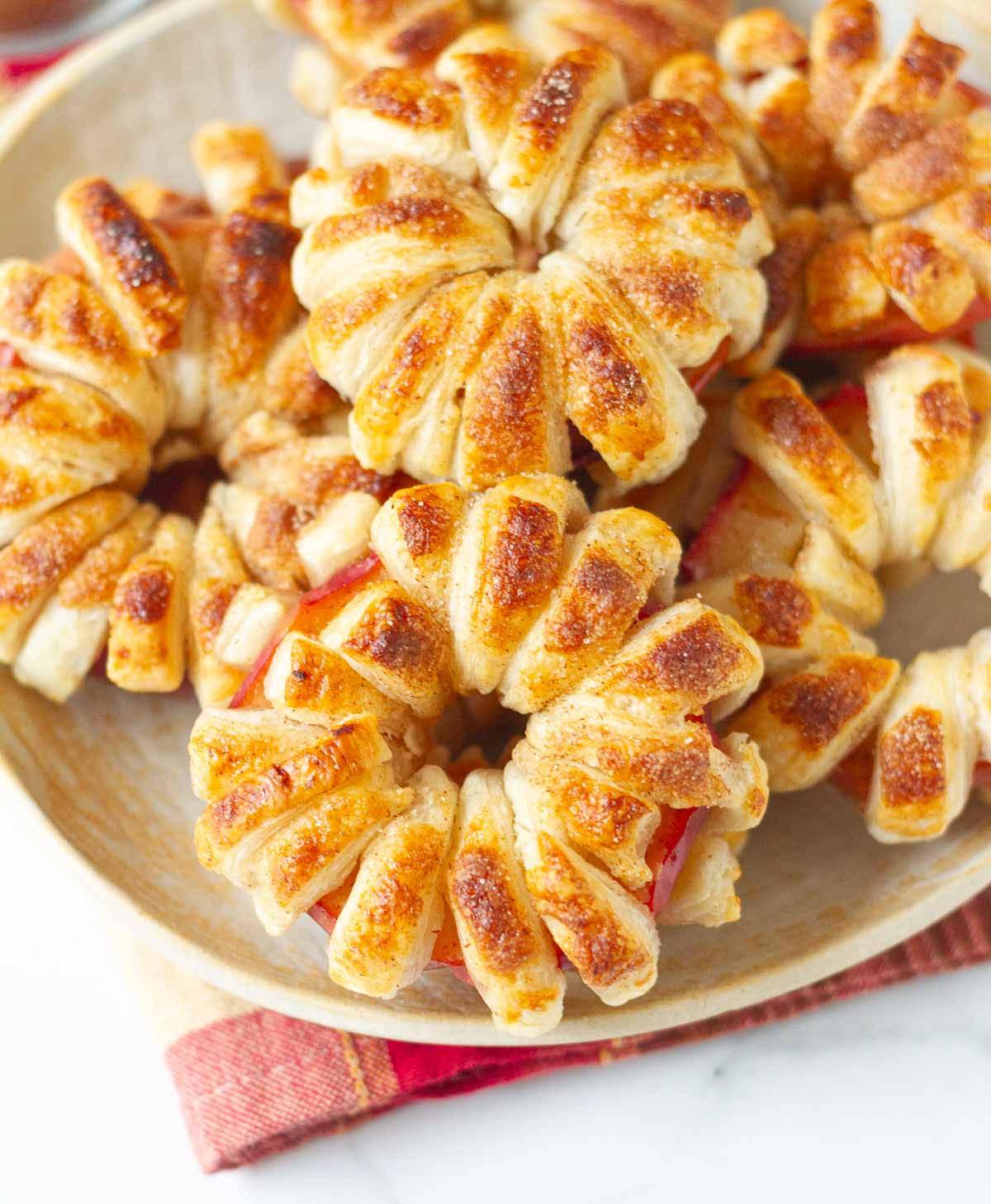 Puff pastry apple donuts on a plate.
