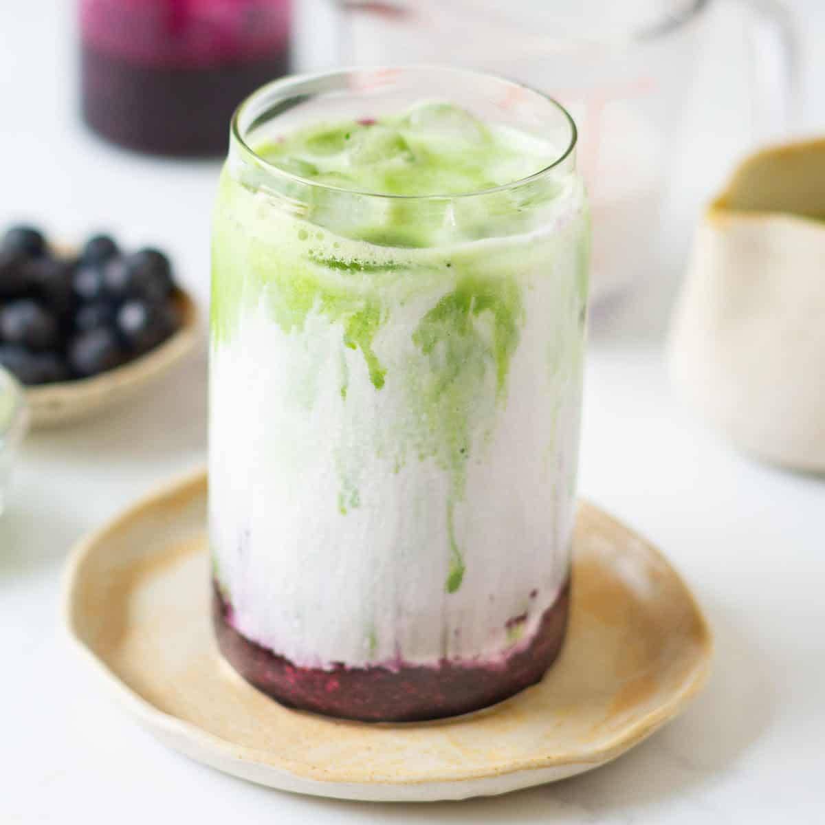 Blueberry matcha latte in a glass.