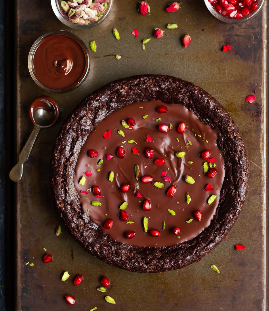 chocolate cake with ganache on a black tray.