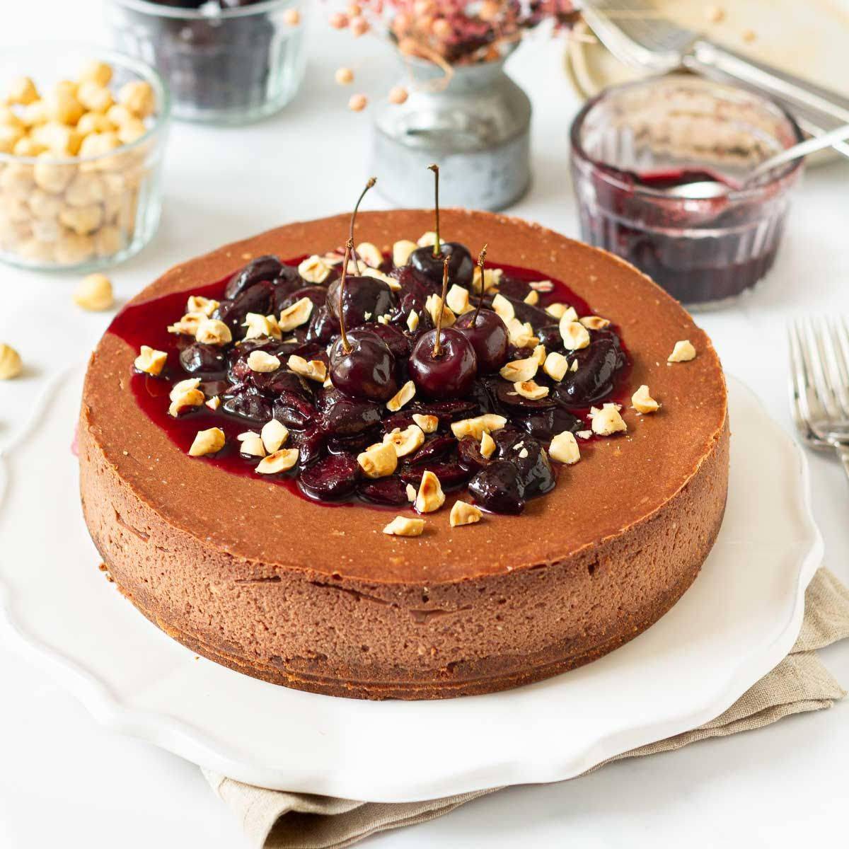 Chocolate cheesecake with cherry sauce and hazelnuts on a platter