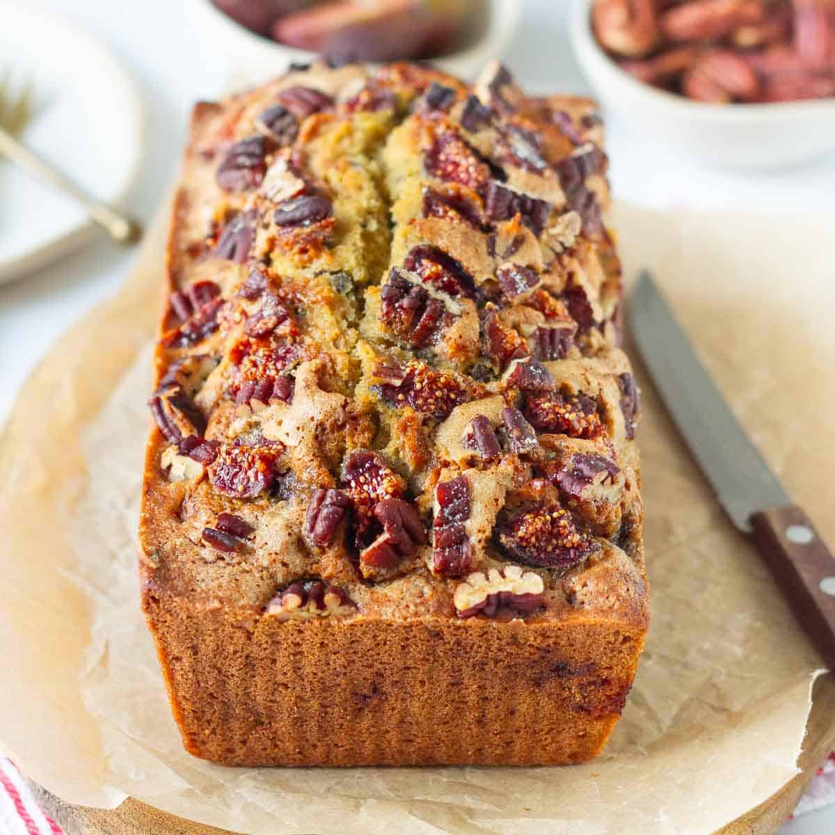 a loaf of fig bread with a knife on the side.