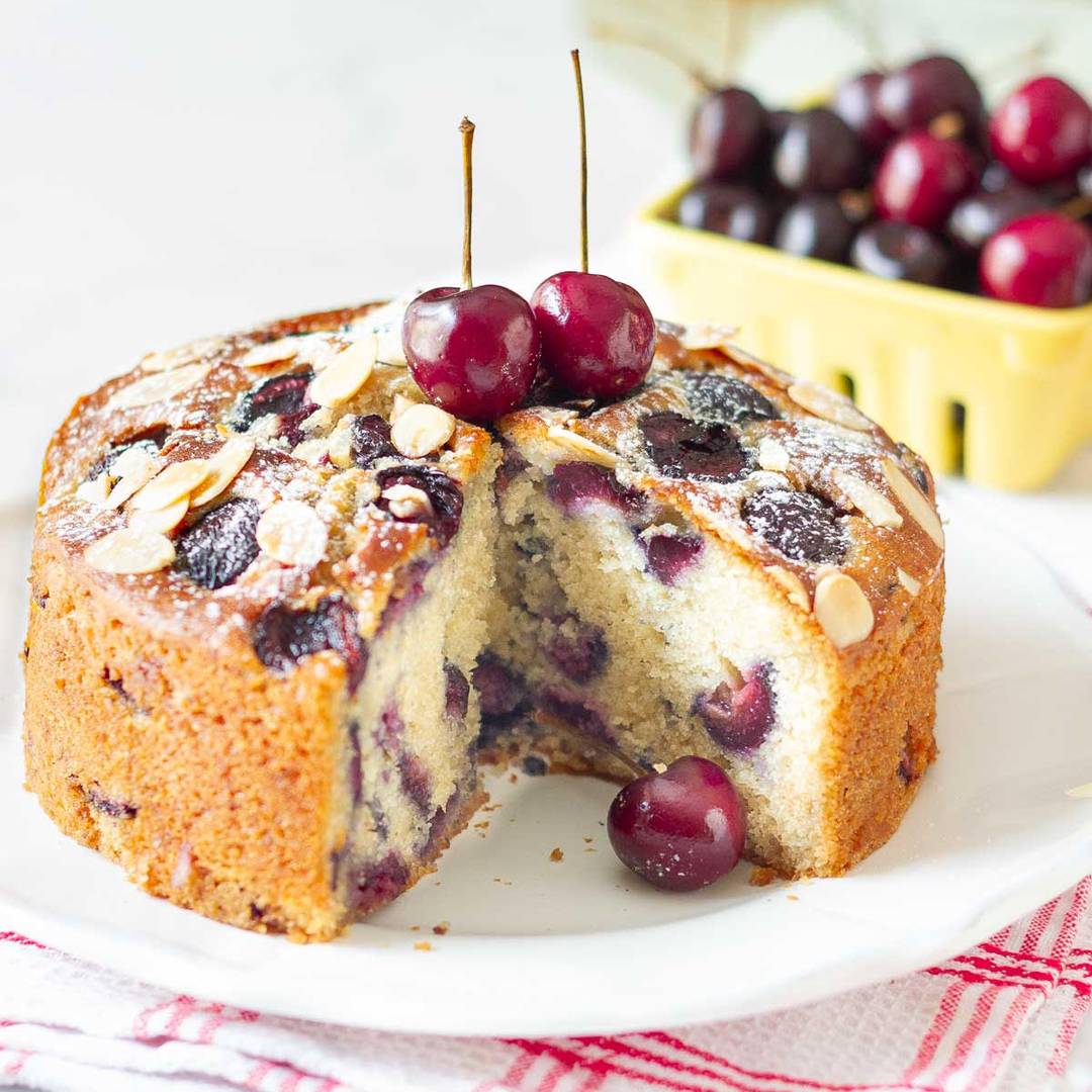 A cake on a plate with a slice taken out.
