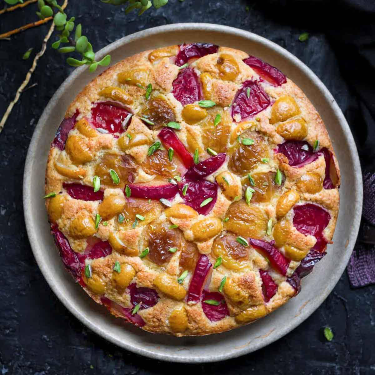 Cake with plums and apricots on a plate.