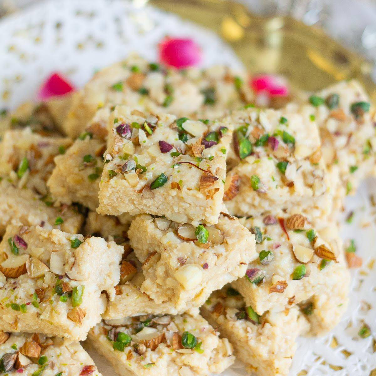 Pieces of kalakand stacked on a tray.