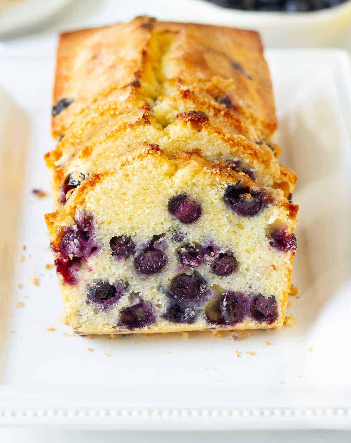 Sliced blueberry and lemon bread on a platter.