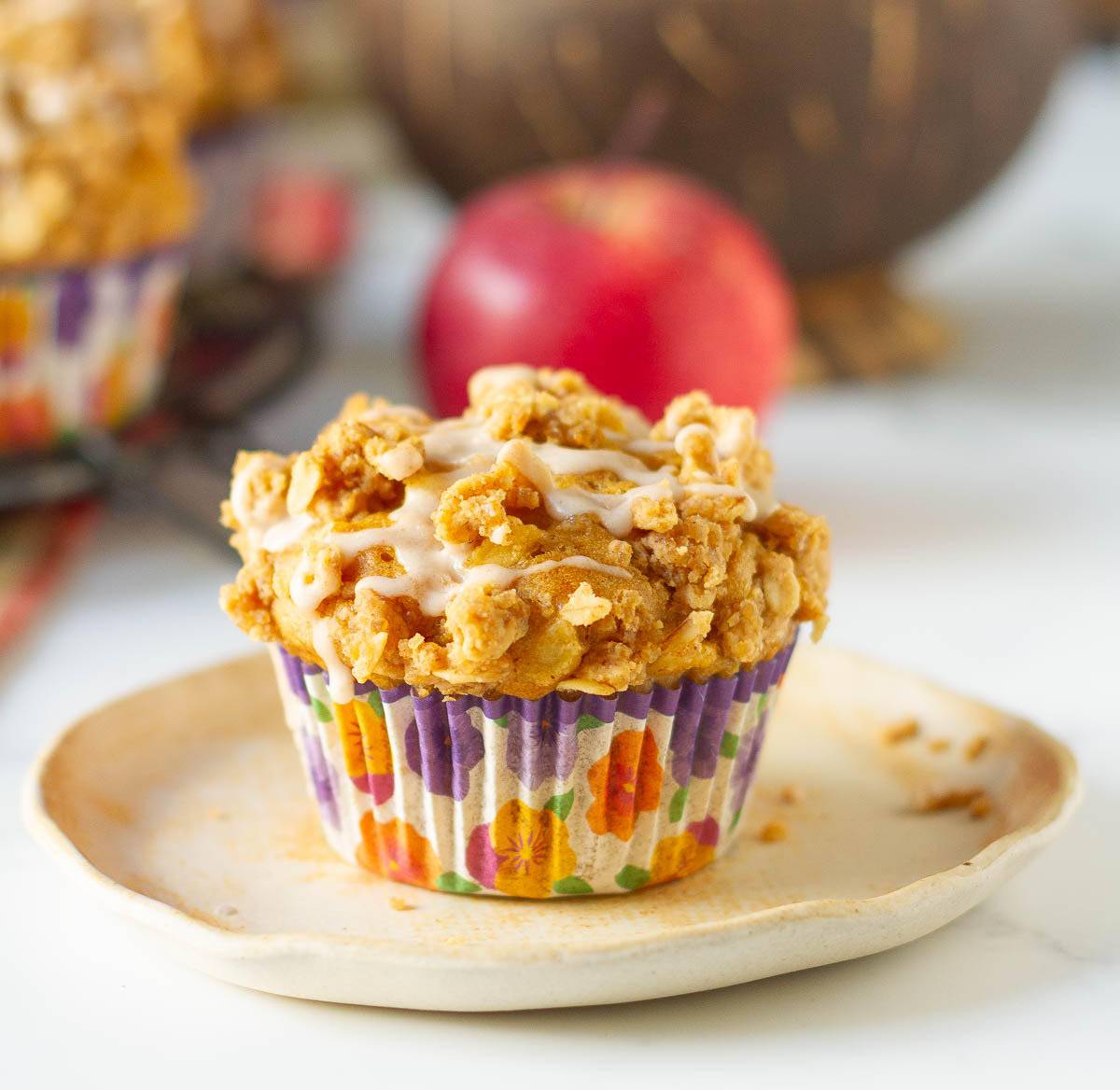 An apple peanut butter muffin on a small plate.
