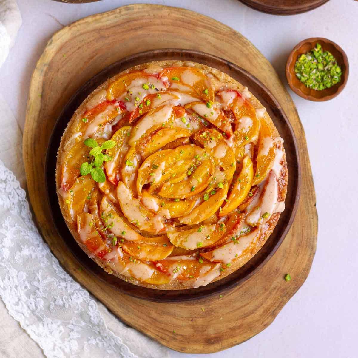 A peach cobbler cake on a wooden platter.