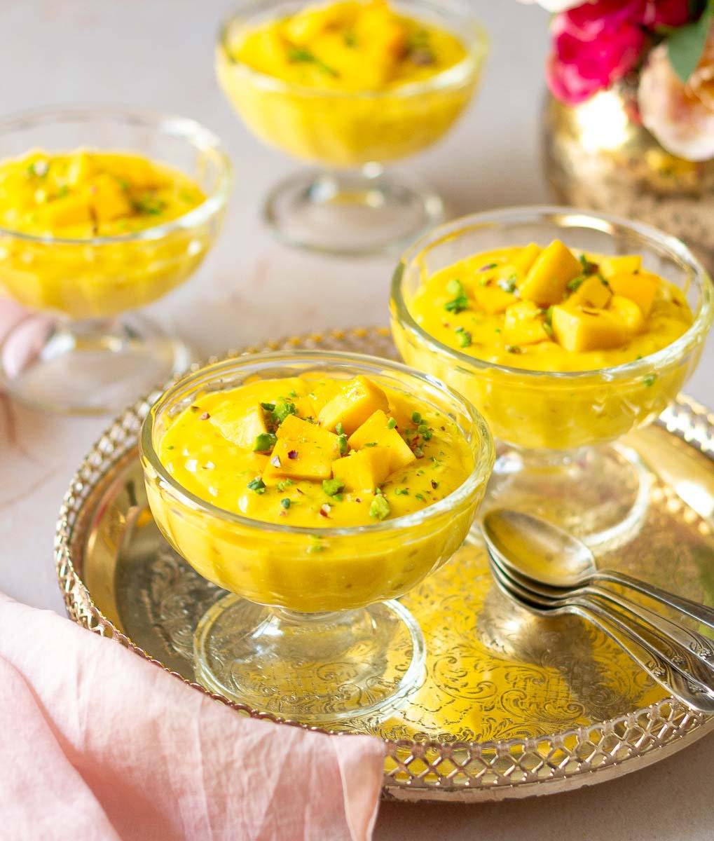 4 dessert glasses filled with mango sago pudding.