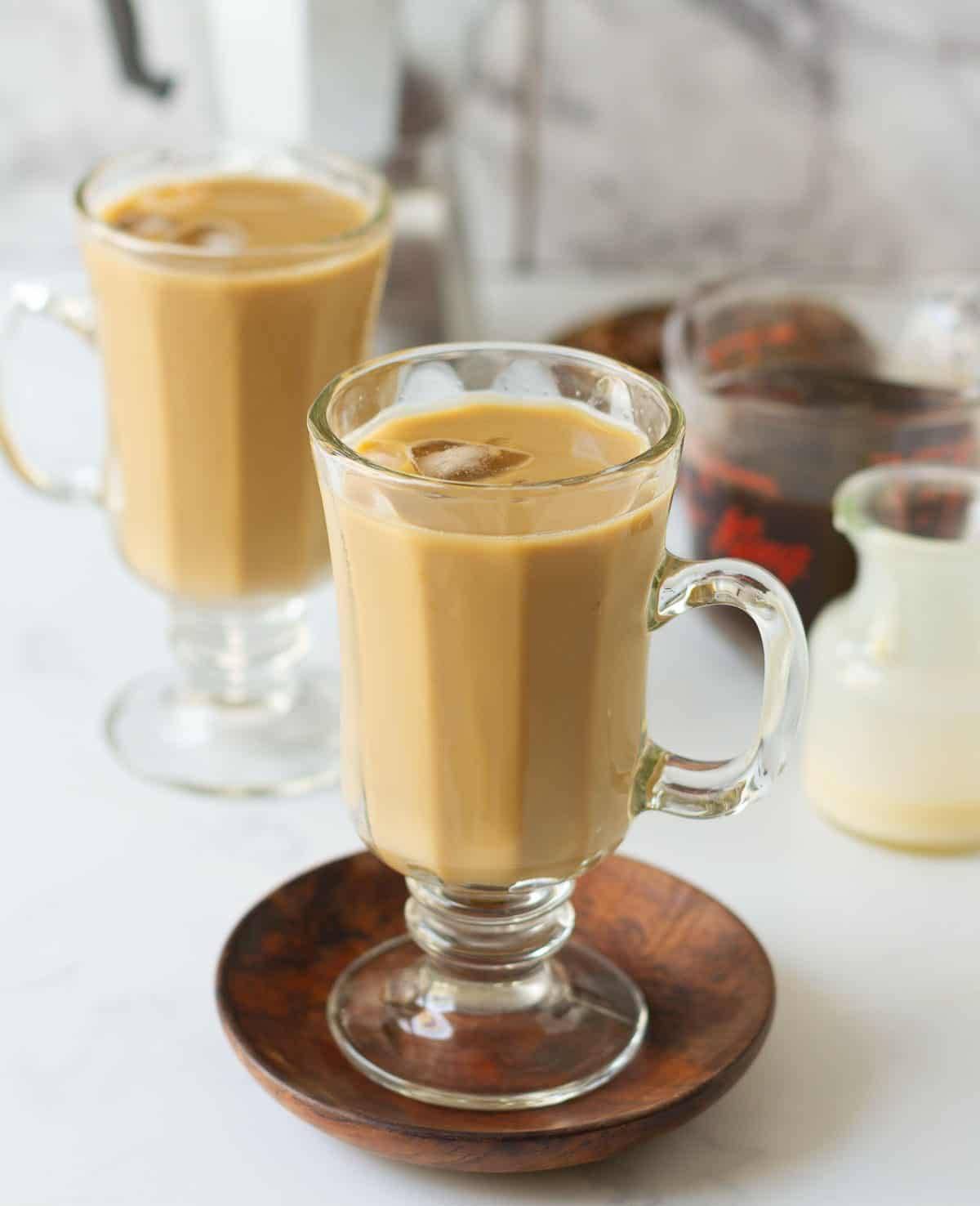 2 glasses of Vietnamese iced coffee with ingredients around.