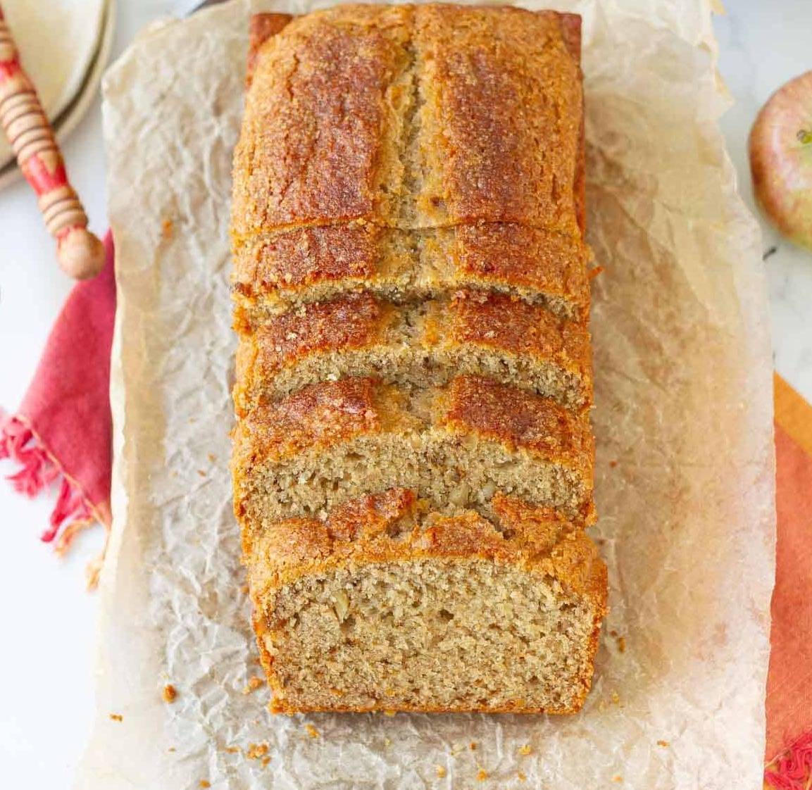a sliced loaf of apple butter bread on parchment paper.