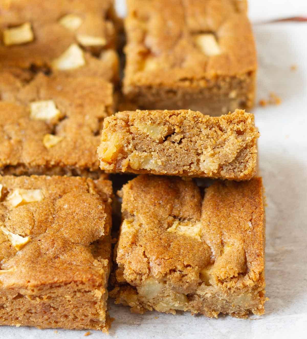 Squares of apple blondies on parchment paper.