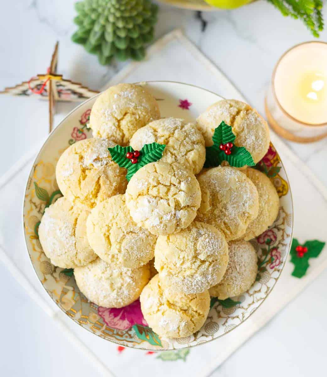 Lemon crinkle cookies on a serving platter with Christmas decorations.