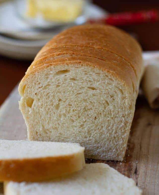 Sliced sandwich bread on a wooden board.
