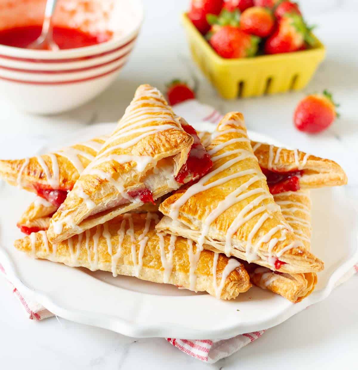 strawberry turnovers on a plate with ingredients in the background.