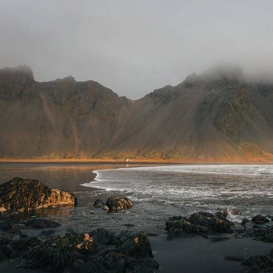 A rocky beach with a mountain in the background
