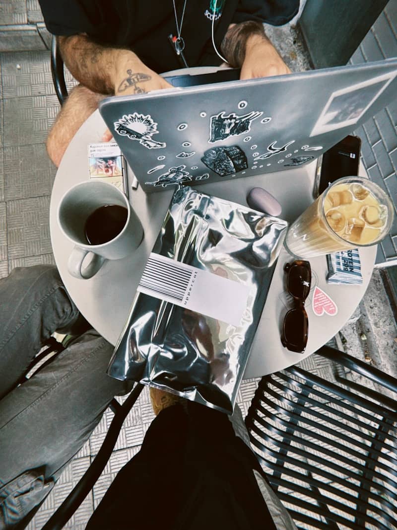 People at a table with coffee and laptop