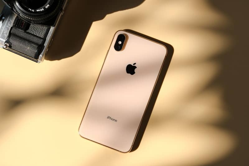 Gold iPhone and vintage camera on a textured background