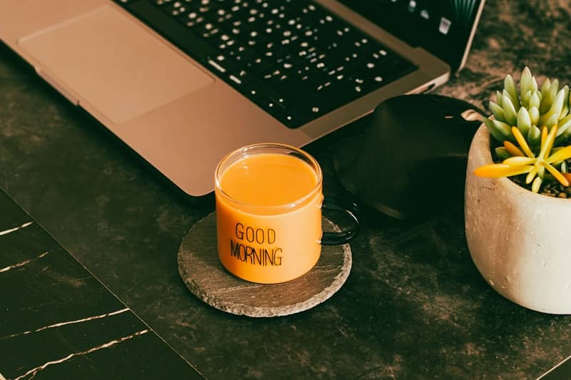 Orange juice in glass with "good morning" text.