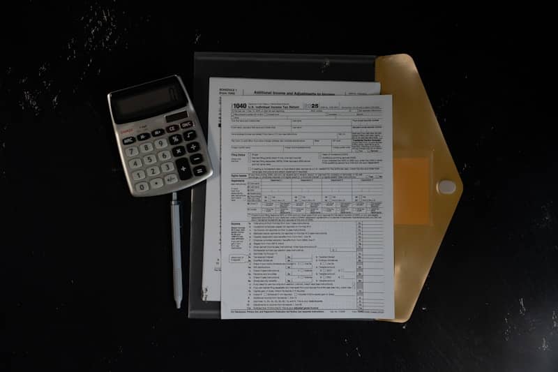 Calculator and papers in a folder on a dark surface
