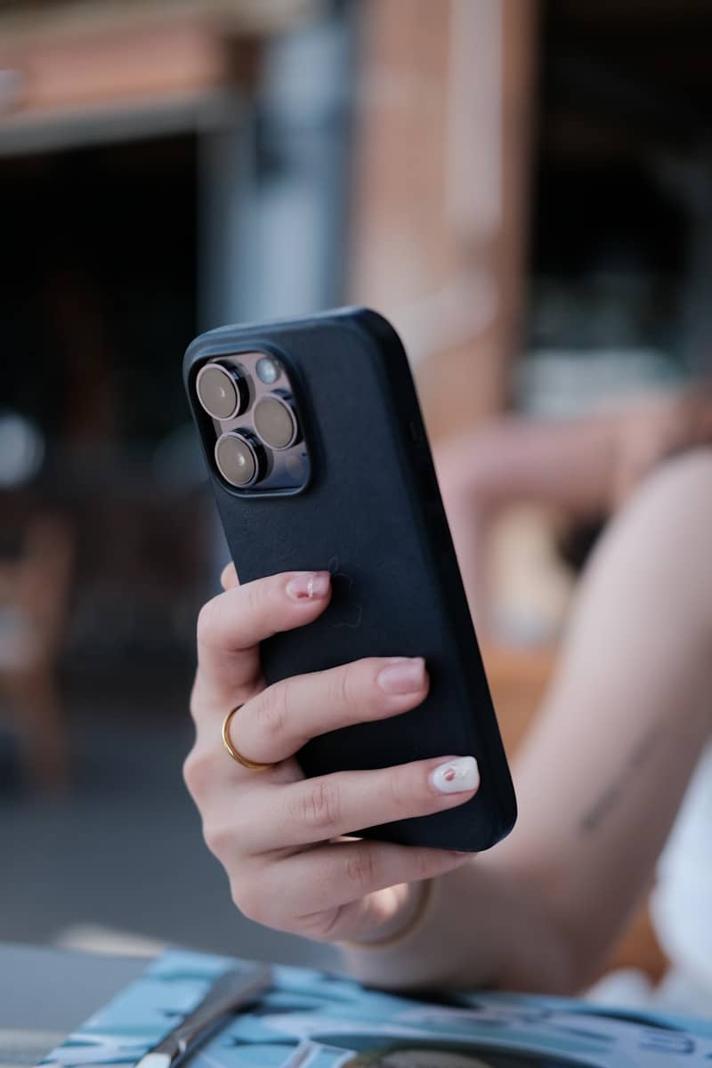 Woman holding a black smartphone with a camera lens