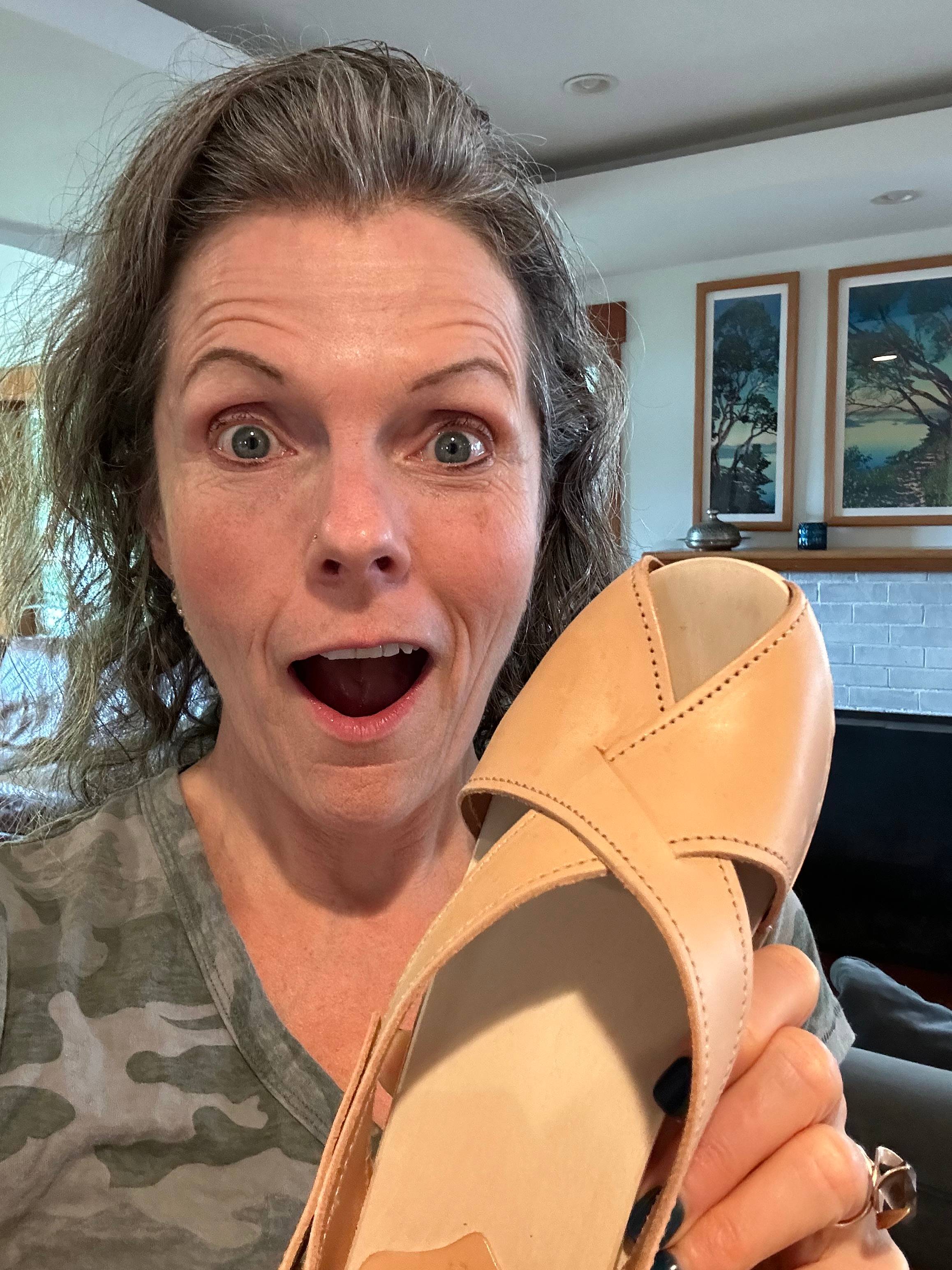 Michele Lisenbury Christensen holding up a shoe and making a shocked face