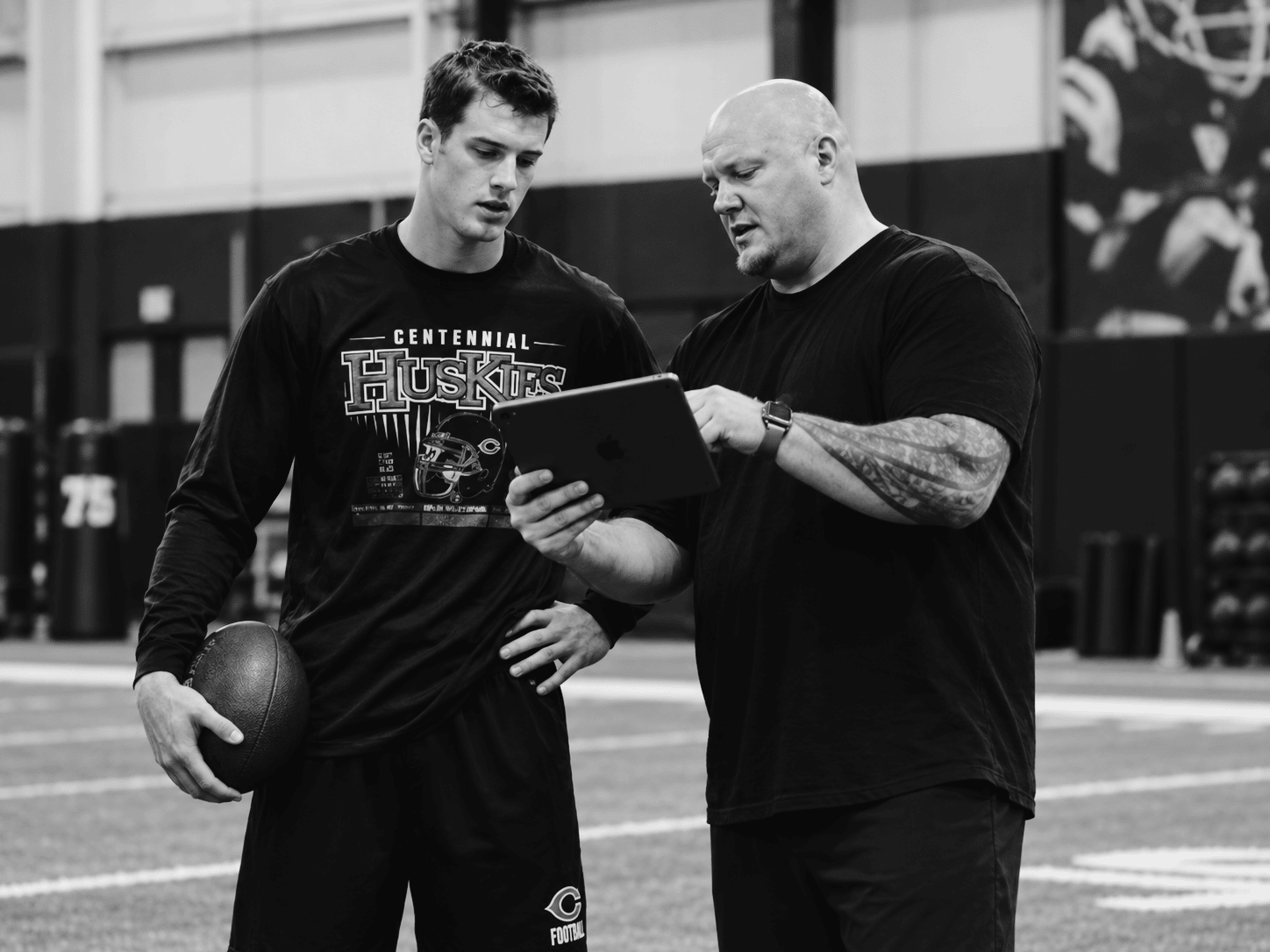 Nate Longshore reviewing quarterback video on an iPad during private training