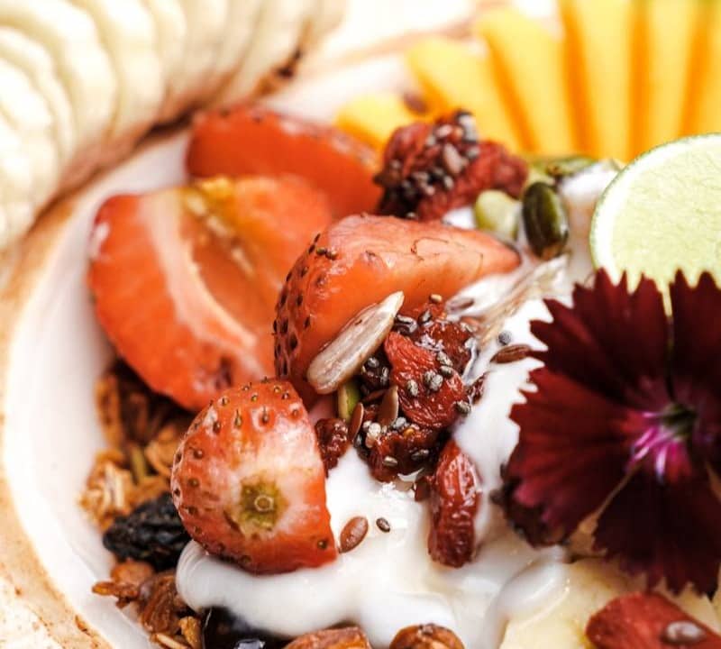 Granola with yogurt, strawberries, banana, and lime