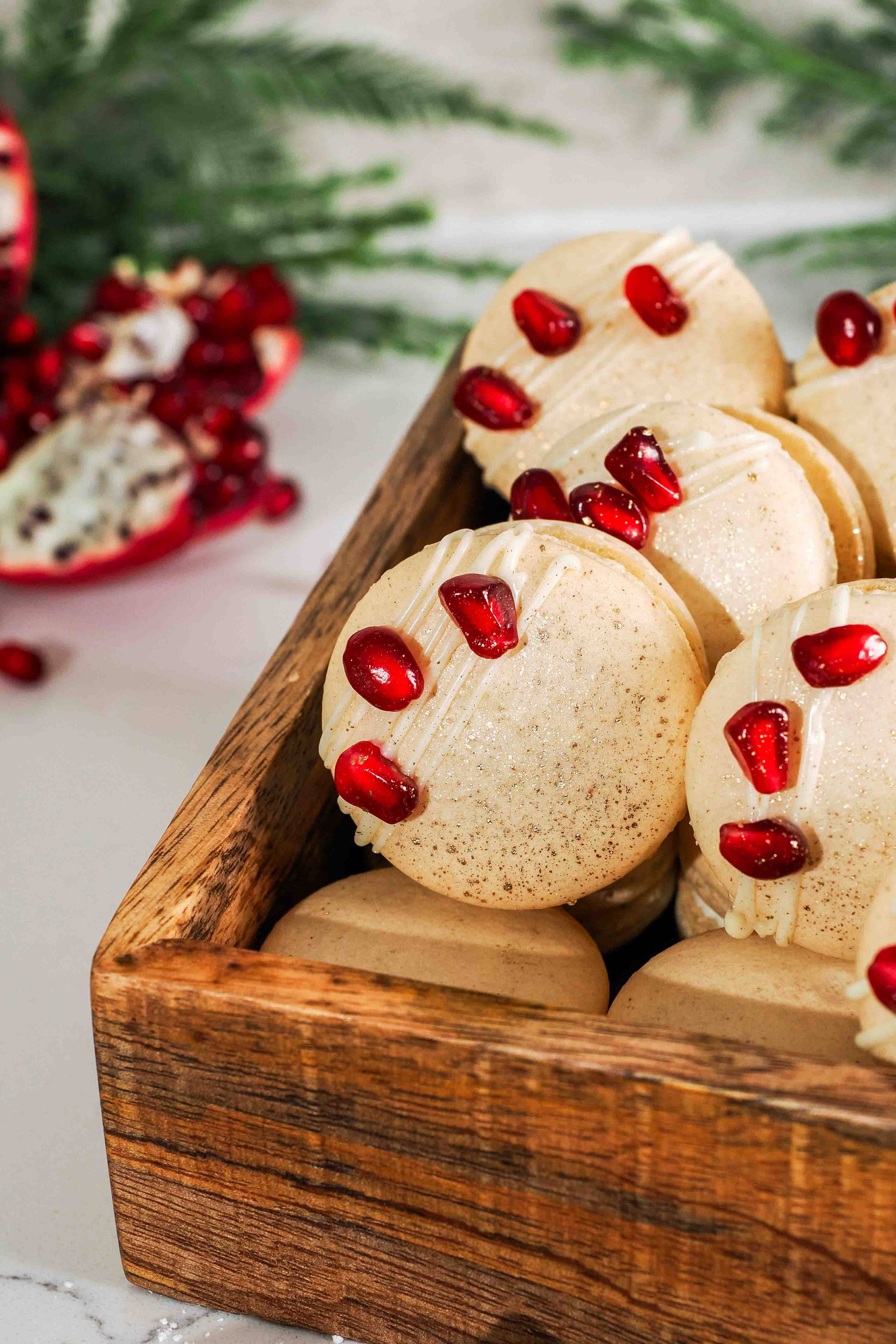 A wooden box filled with white chocolate pomegranate macarons
