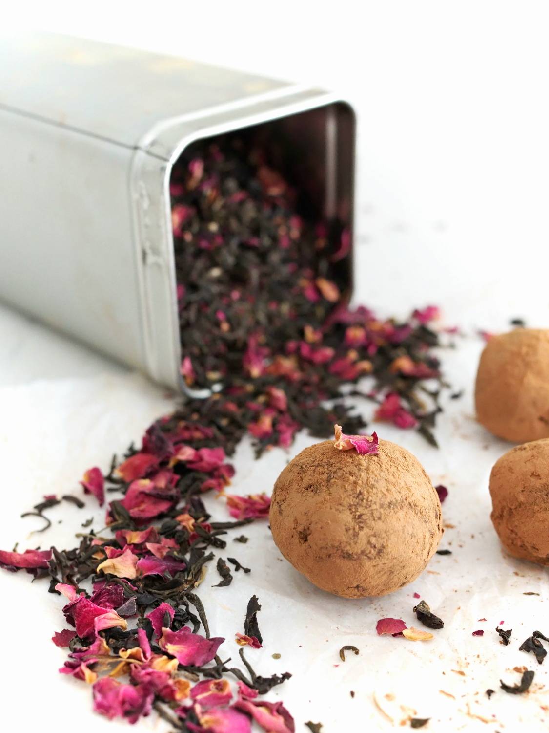 A close-up of a homemade truffle rolled in cocoa powder.