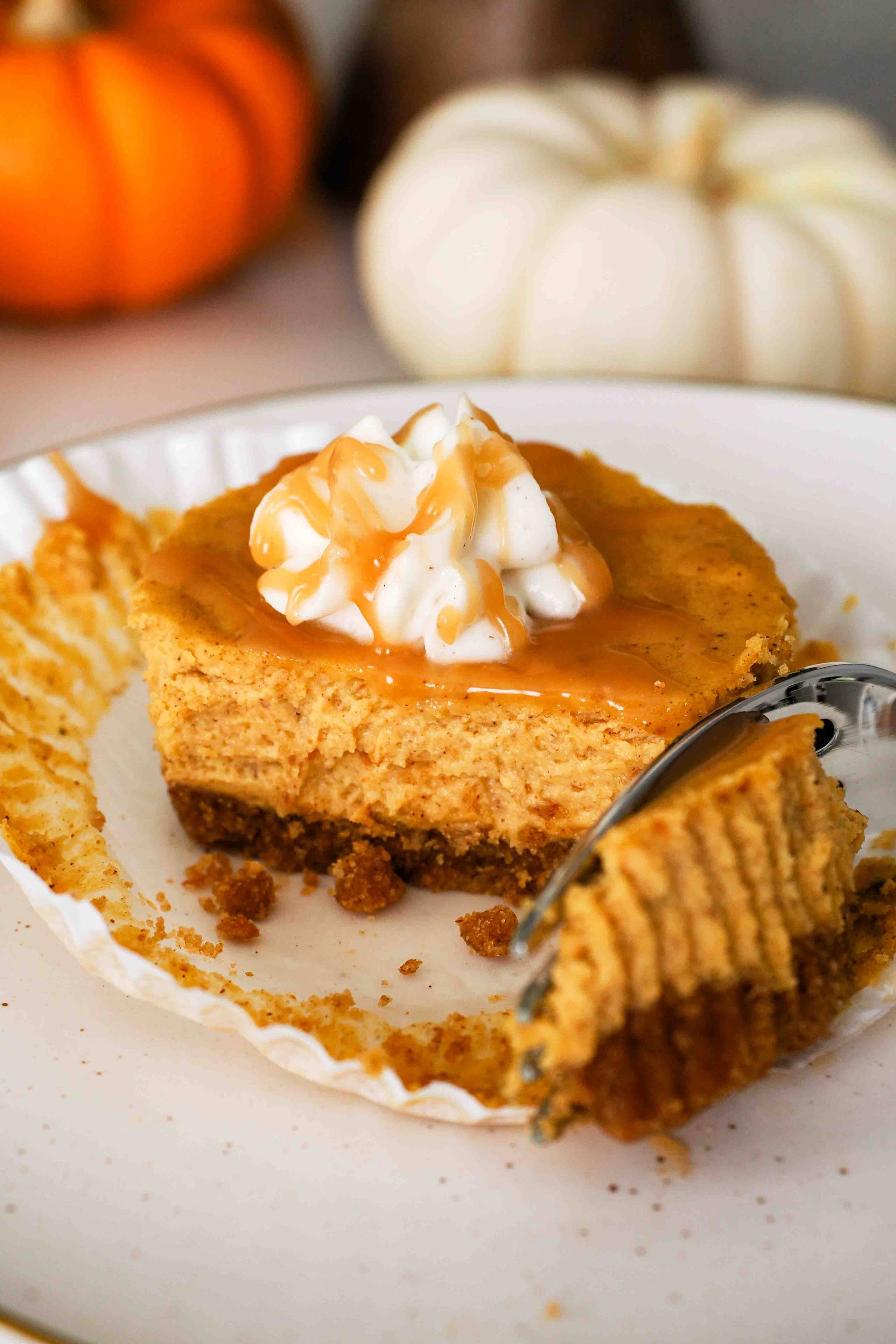 A fork removes a piece of mini pumpkin cheesecake.