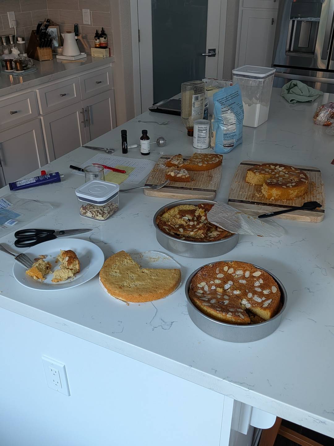A kitchen counter with five cakes, all missing some pieces