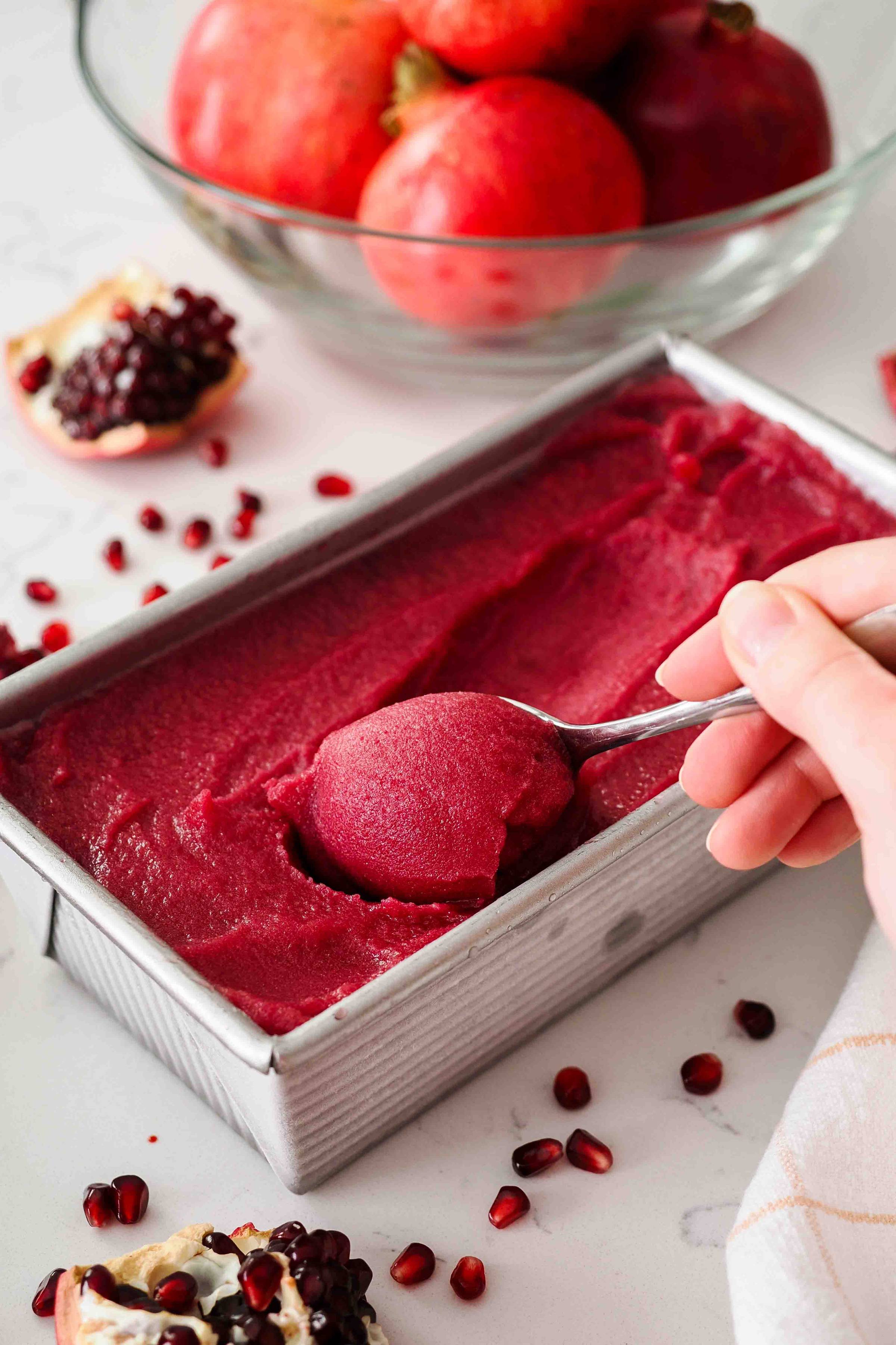 A spoon scoops pomegranate sorbet.