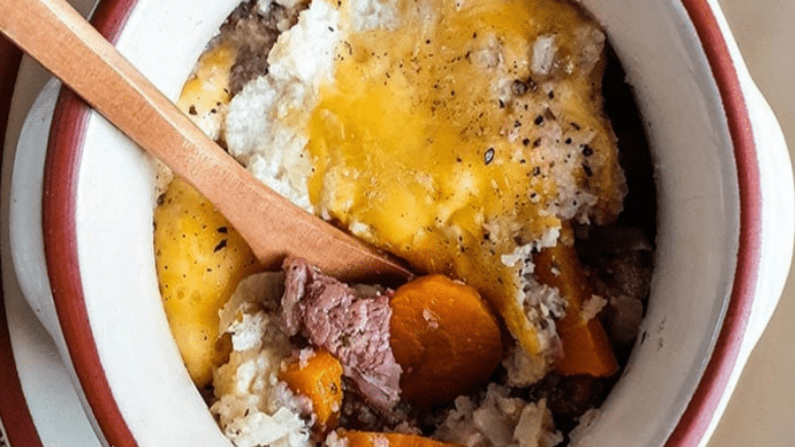 A hearty beef stew with chunks of meat, carrots, and potatoes, garnished with herbs