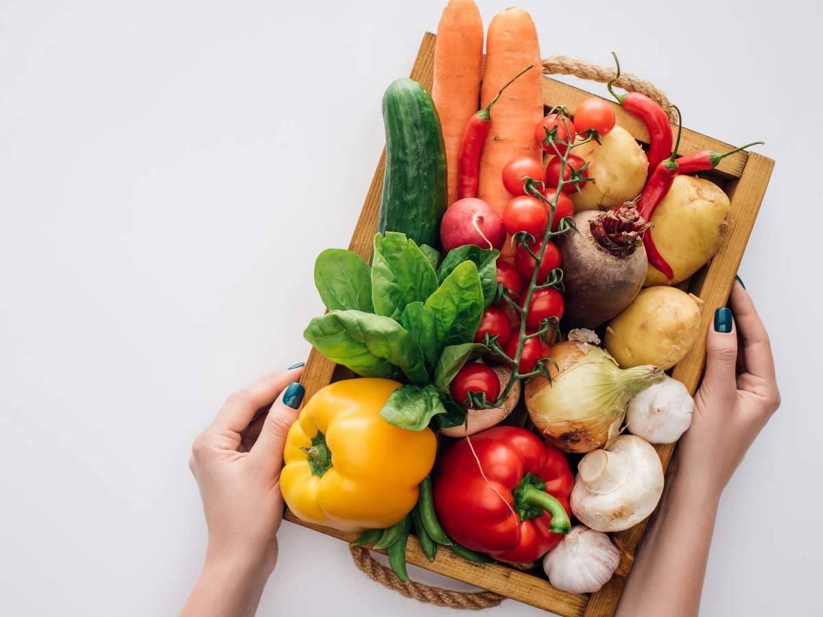 A wooden tray filled with fresh vegetables.